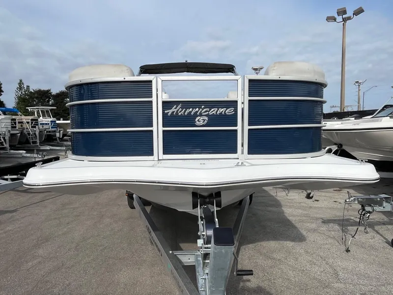 Slide: The Image of 2021 Hurricane FunDeck 236SB OB boat on trailer, front view, blue and white design. - 4