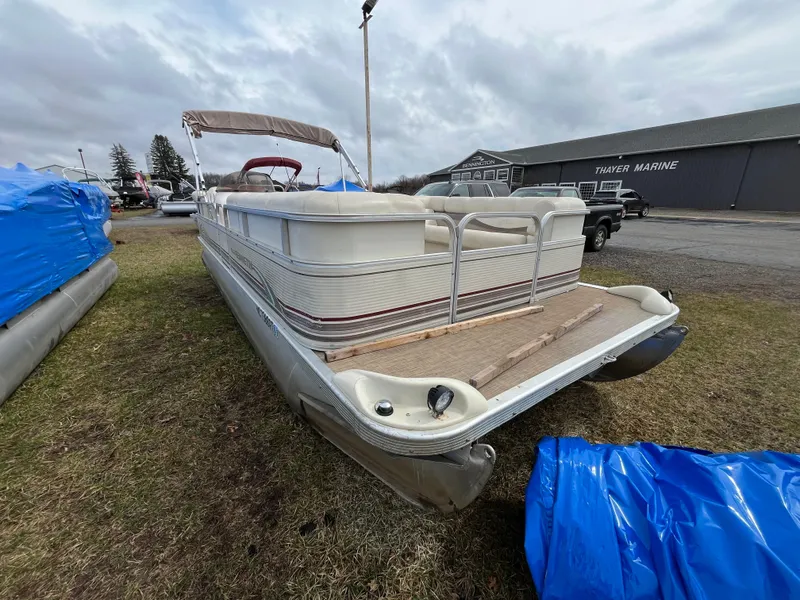 Slide: The Image of 1998 Bennington LX 2280 pontoon boat at Thayer Marine, parked on grass. - 10