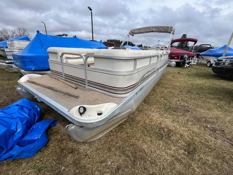 Slide: The Image of 1998 Bennington LX 2280 pontoon boat on grass, surrounded by covered boats. - 2