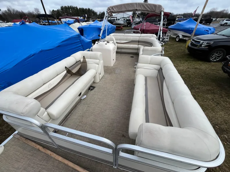 Slide: The Image of 1998 Bennington LX 2280 pontoon boat with beige seating, displayed outdoors. - 3