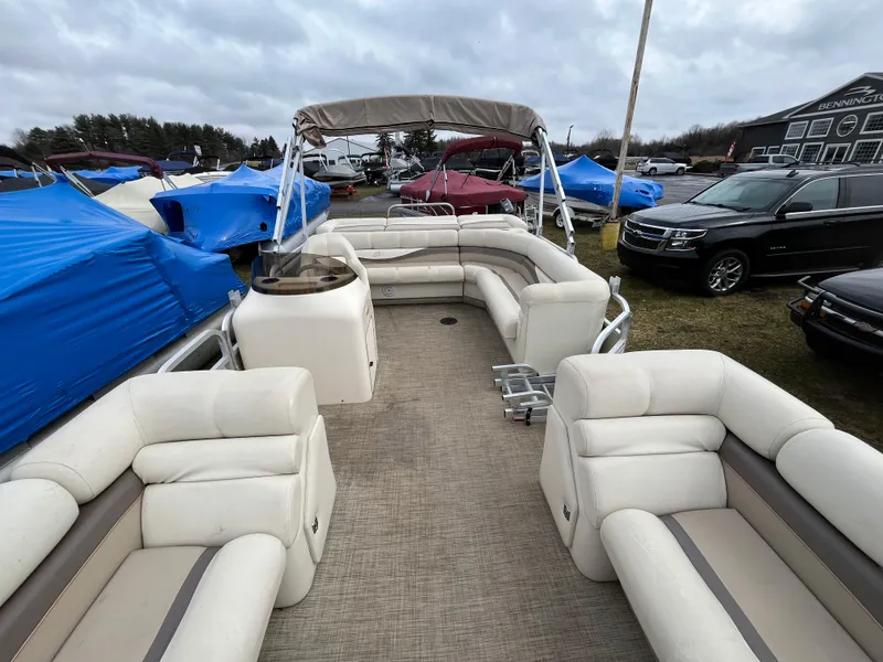 Slide: The Image of 1998 Bennington LX 2280 pontoon boat with beige seating and canopy, parked outdoors. - 4