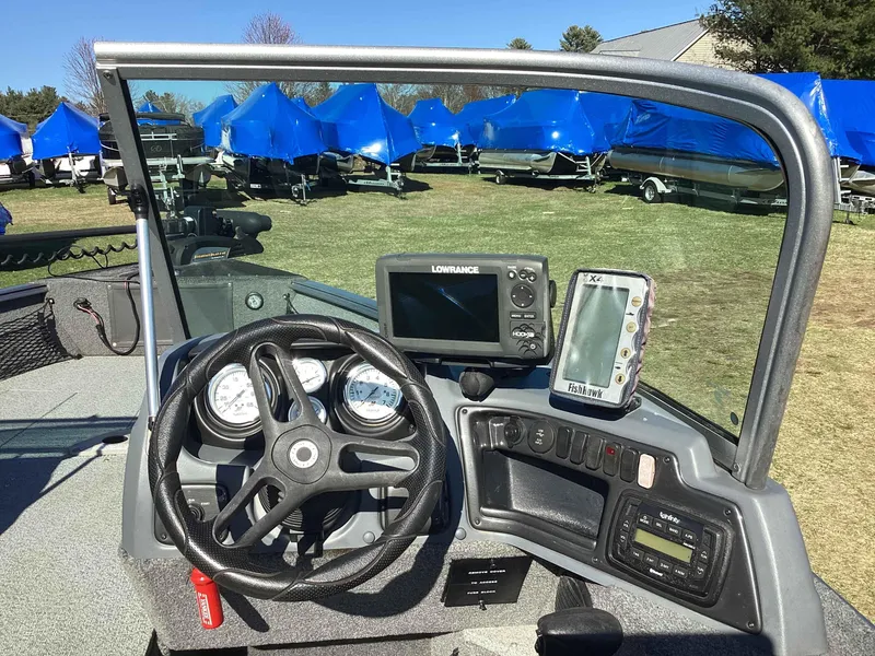 Slide: The Image of 2016 Lund 1775 Impact boat dashboard with steering wheel and navigation equipment. - 7