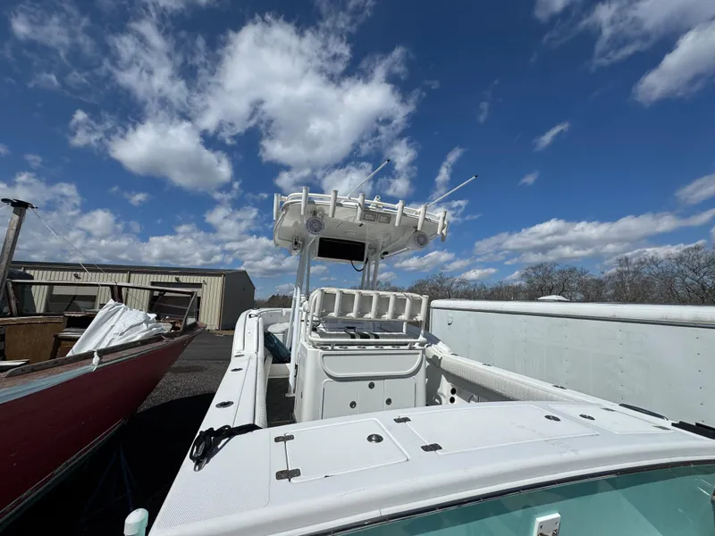 Slide: The Image of 2006 Buddy Davis 28 Center Console boat under a bright blue sky with clouds. - 5