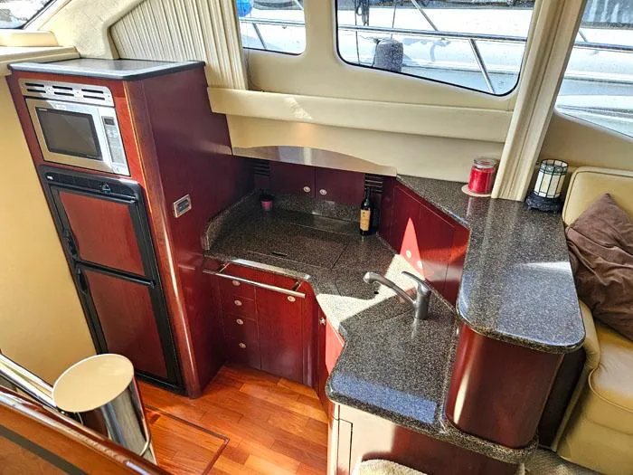 Slide: The Image of 2006 Sea Ray 44 Sedan Bridge yacht kitchen with modern appliances and sleek countertops. - 10