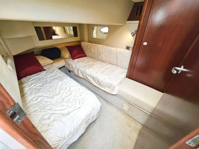 Slide: The Image of 2006 Sea Ray 44 Sedan Bridge cabin with twin beds, elegant decor, and wooden accents. - 14