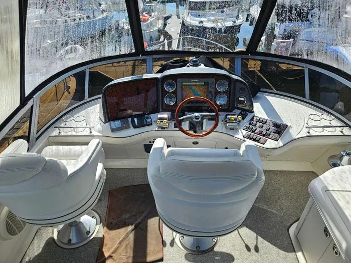 Slide: The Image of 2006 Sea Ray 44 Sedan Bridge helm with dual seats and navigation controls. - 17