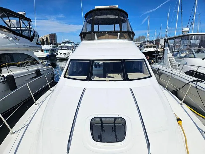 Slide: The Image of 2006 Sea Ray 44 Sedan Bridge yacht docked at marina under clear blue sky. - 23