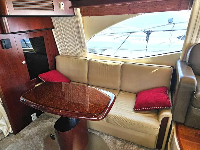 Slide: The Image of Luxurious interior of 2006 Sea Ray 44 Sedan Bridge with beige sofa and wooden table. - 7