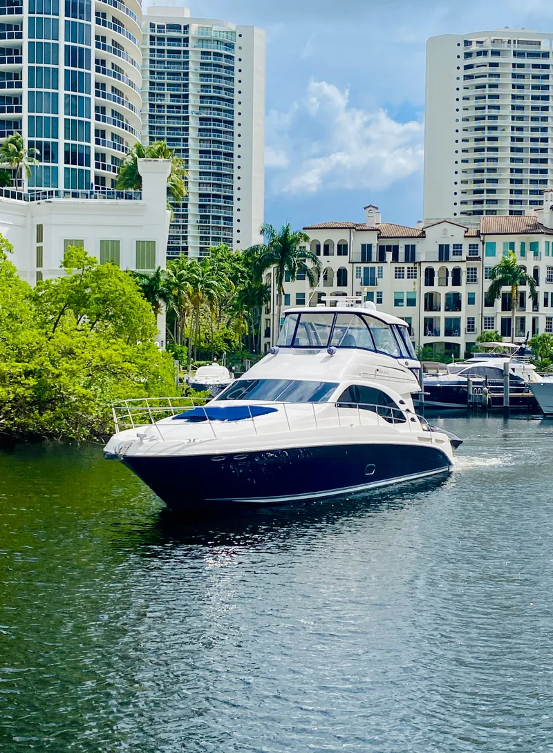 The Image of 2006 Sea Ray 580 Sedan Bridge yacht cruising near waterfront buildings. - 0