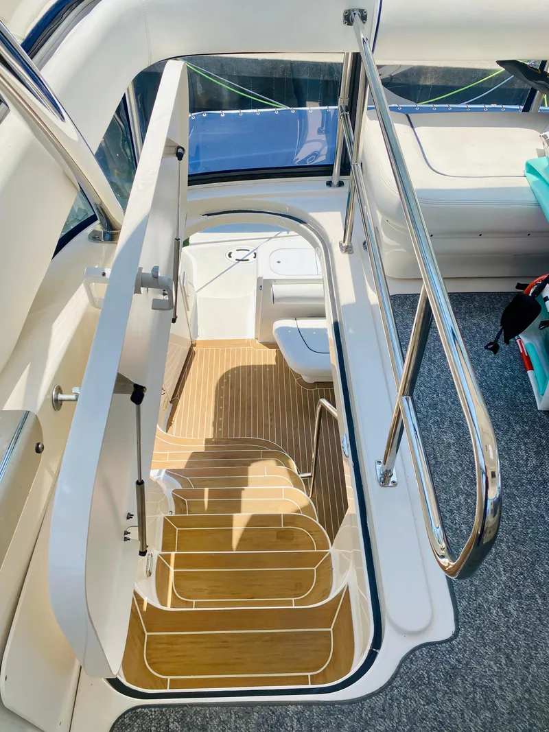 Slide: The Image of Staircase on 2006 Sea Ray 580 Sedan Bridge yacht with wooden steps and metal railing. - 21