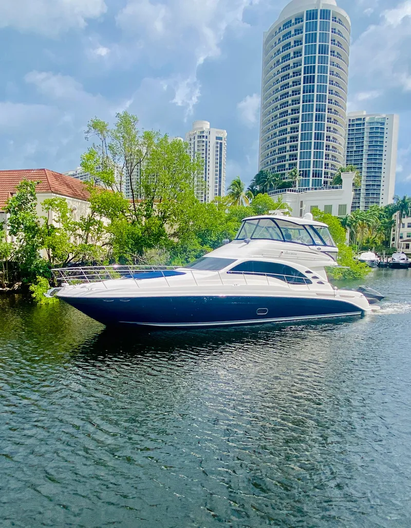 Slide: The Image of 2006 Sea Ray 580 Sedan Bridge yacht cruising on a river with cityscape background. - 3