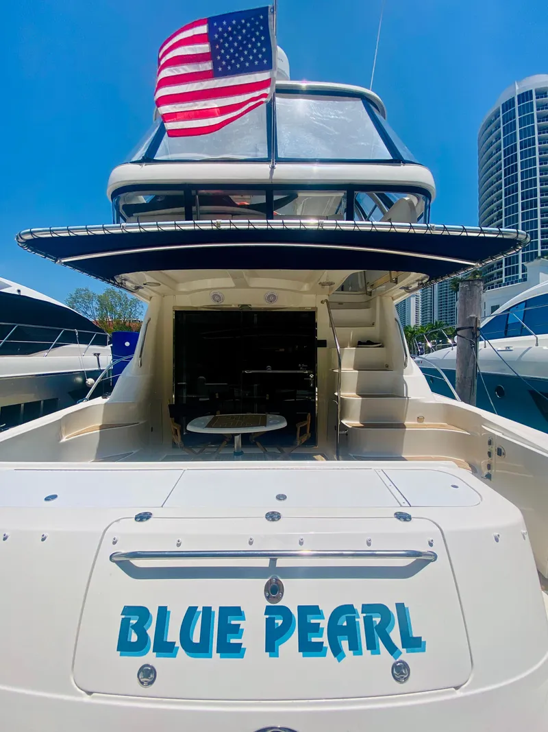 Slide: The Image of 2006 Sea Ray 580 Sedan Bridge yacht "Blue Pearl" with American flag, docked in marina. - 8