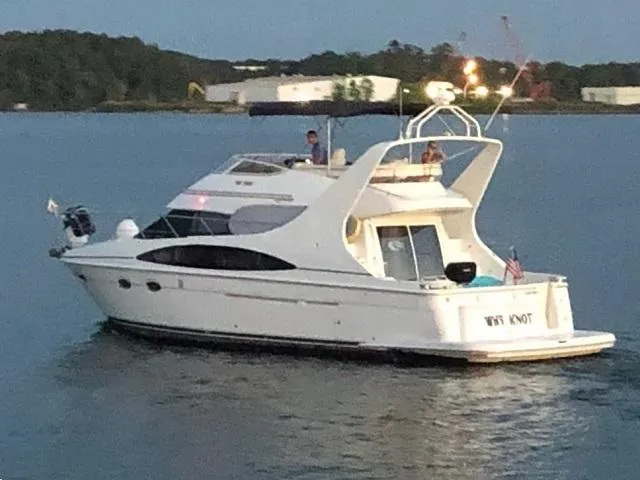 Slide: The Image of 2003 Carver 410 Sport Sedan yacht cruising on a calm lake at dusk. - 10