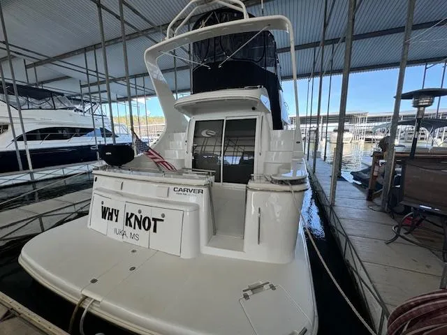 Slide: The Image of 2003 Carver 410 Sport Sedan docked in marina, rear view with "Why Knot" nameplate. - 18