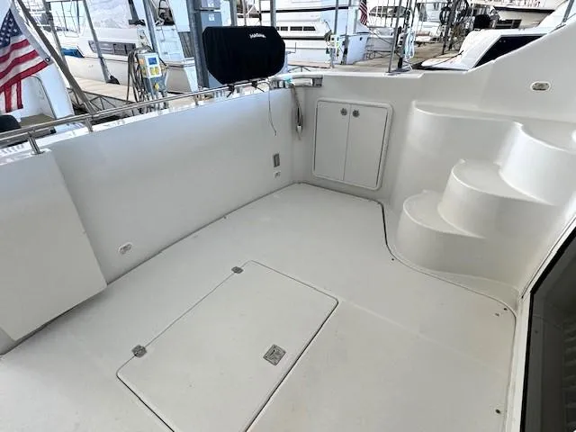 Slide: The Image of 2003 Carver 410 Sport Sedan yacht deck with storage and steps, docked with American flag. - 22