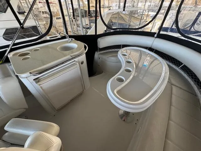 Slide: The Image of 2003 Carver 410 Sport Sedan interior with seating, table, and kitchenette. - 36