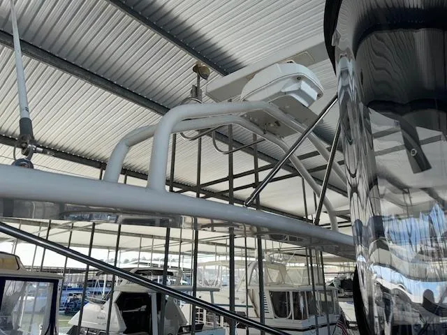 Slide: The Image of 2003 Carver 410 Sport Sedan radar arch under a metal roof in a marina. - 39