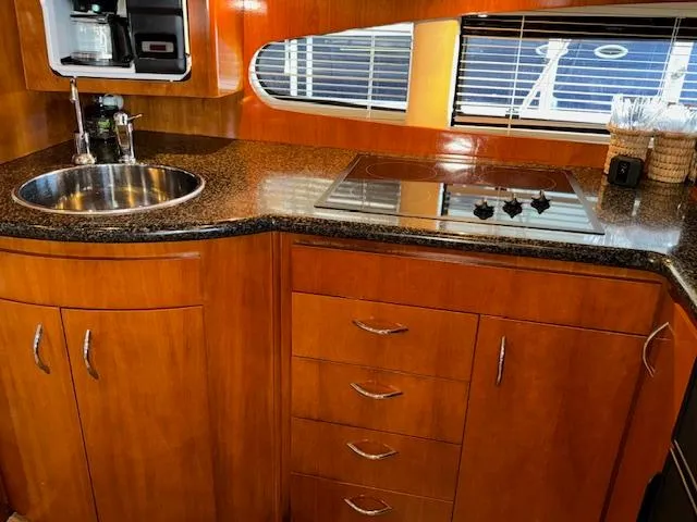 Slide: The Image of 2003 Carver 410 Sport Sedan kitchen with wood cabinetry, sink, and stovetop. - 49