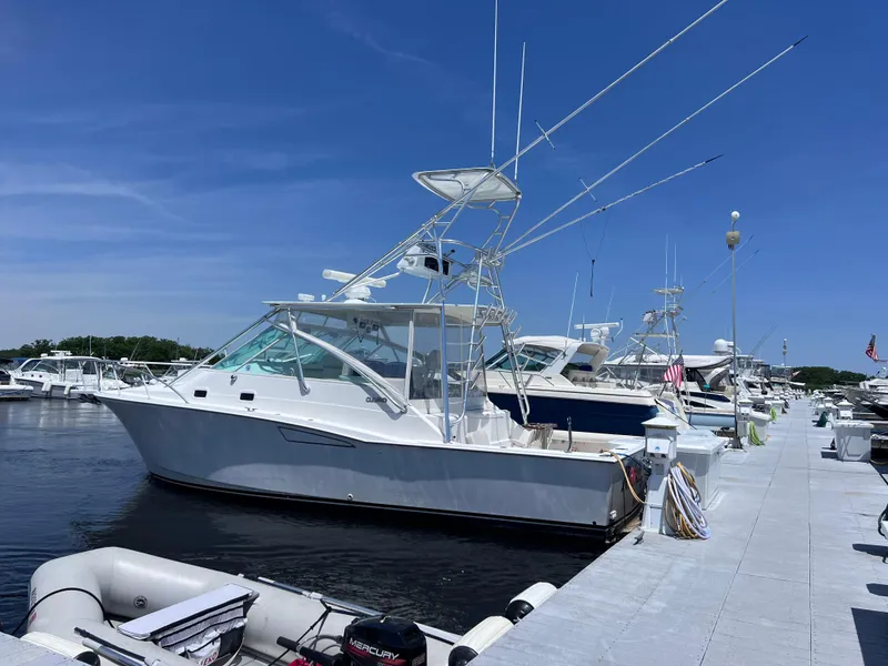 Slide: The Image of 2000 Cabo 35 Express boat docked at marina under clear blue sky. - 1