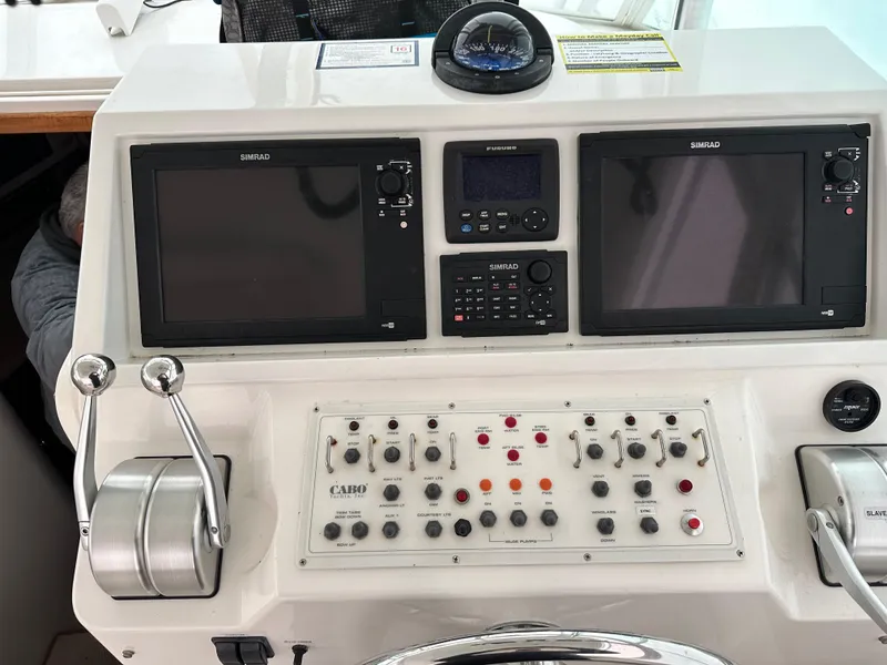 Slide: The Image of Control panel of a 2000 Cabo 35 Express boat with navigation screens and controls. - 4