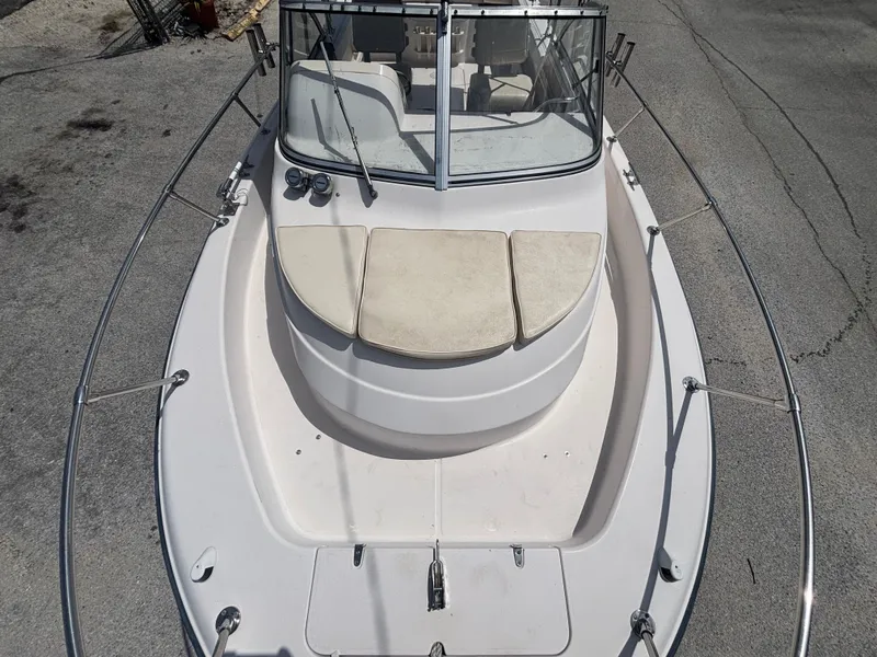 Slide: The Image of 2000 Grady-White 228 Seafarer boat, white deck, cushioned seating, windshield, docked on pavement. - 15