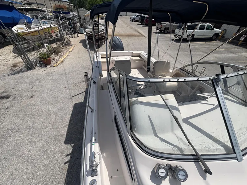 Slide: The Image of 2000 Grady-White 228 Seafarer boat docked, featuring spacious deck and windshield. - 16