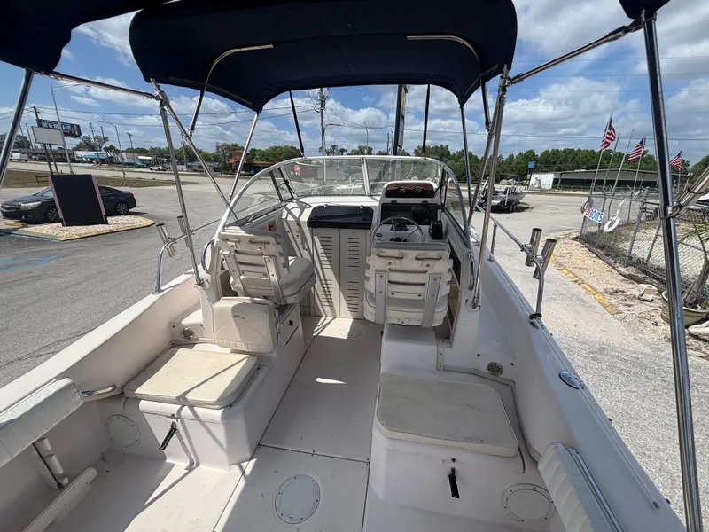Slide: The Image of 2000 Grady-White 228 Seafarer boat interior with seating and canopy, parked outdoors. - 29
