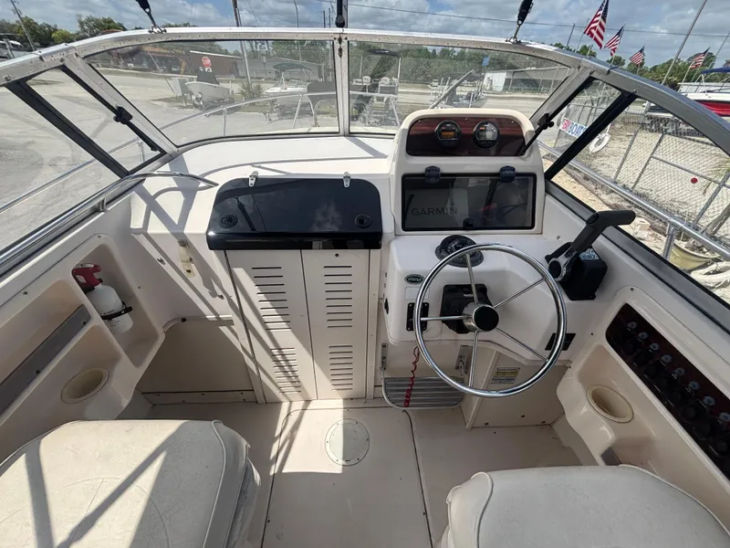 Slide: The Image of 2000 Grady-White 228 Seafarer boat cockpit with steering wheel and dashboard controls. - 32