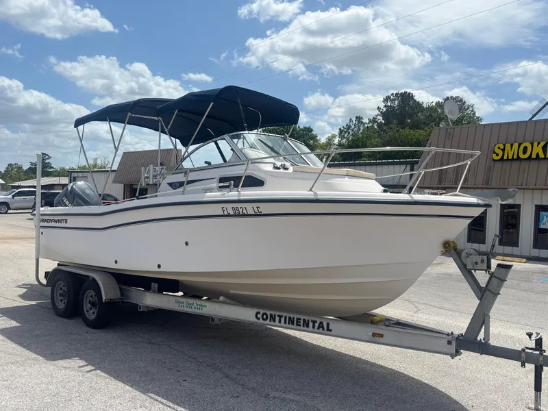 Slide: The Image of 2000 Grady-White 228 Seafarer boat on trailer, parked outdoors under blue sky. - 8