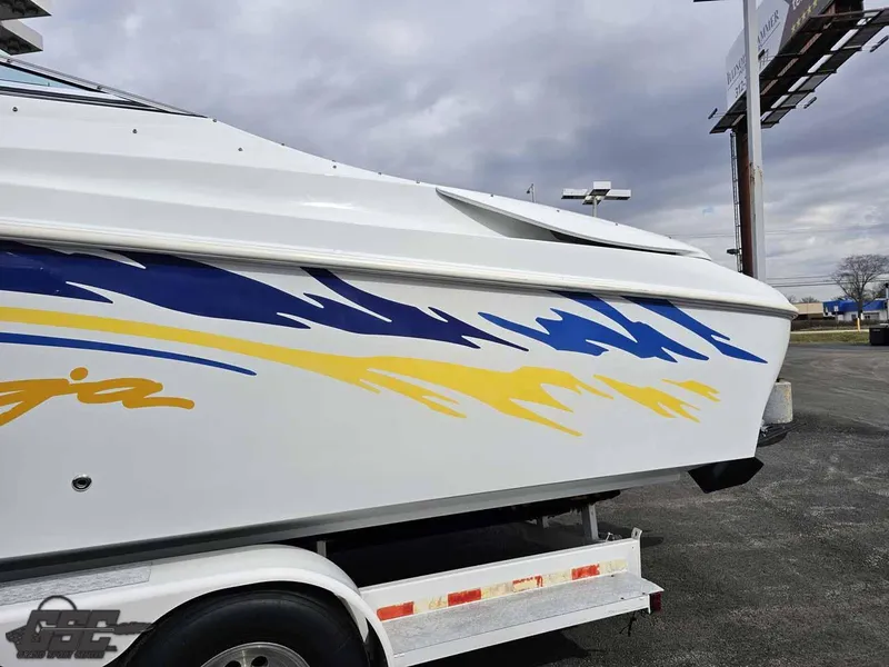 Slide: The Image of 2003 Baja .38 Special boat with blue and yellow graphics on a trailer. - 11