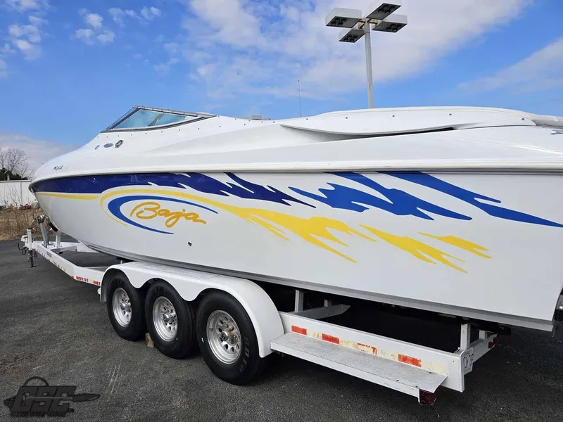 Slide: The Image of 2003 Baja .38 Special boat on trailer, featuring blue and yellow graphics. - 14