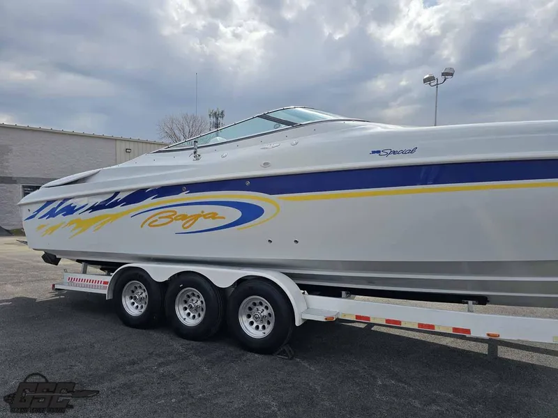 Slide: The Image of 2003 Baja .38 Special speedboat on a triple-axle trailer, featuring blue and yellow accents. - 21