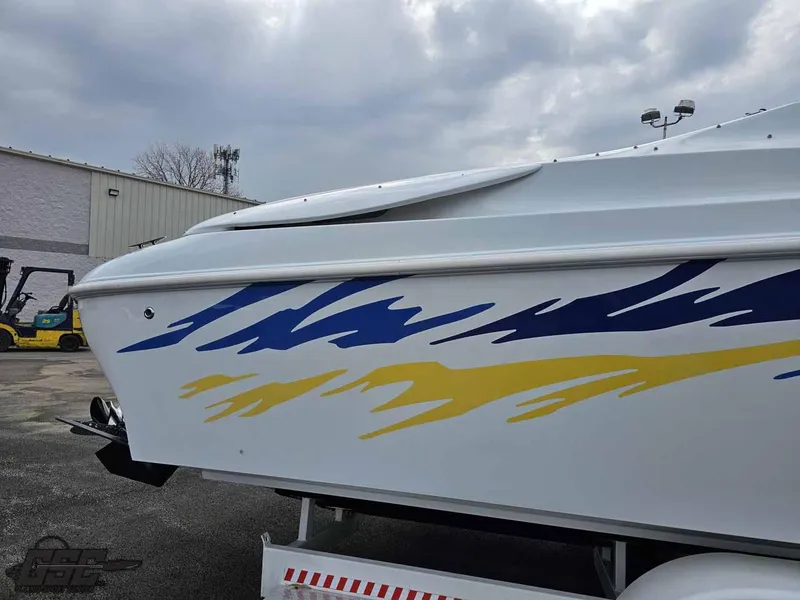 Slide: The Image of 2003 Baja .38 Special boat with blue and yellow graphics on a trailer. - 27