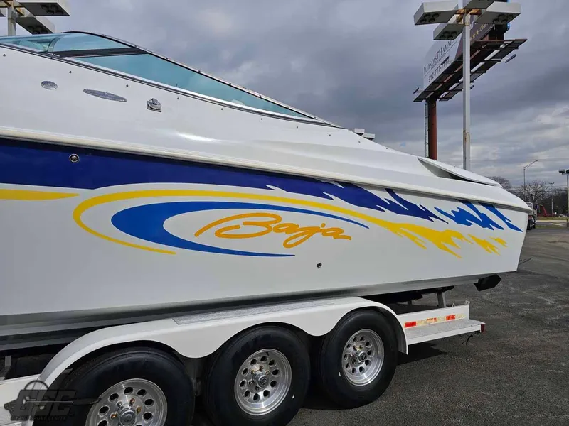 Slide: The Image of 2003 Baja .38 Special boat with vibrant blue and yellow graphics on a trailer. - 6