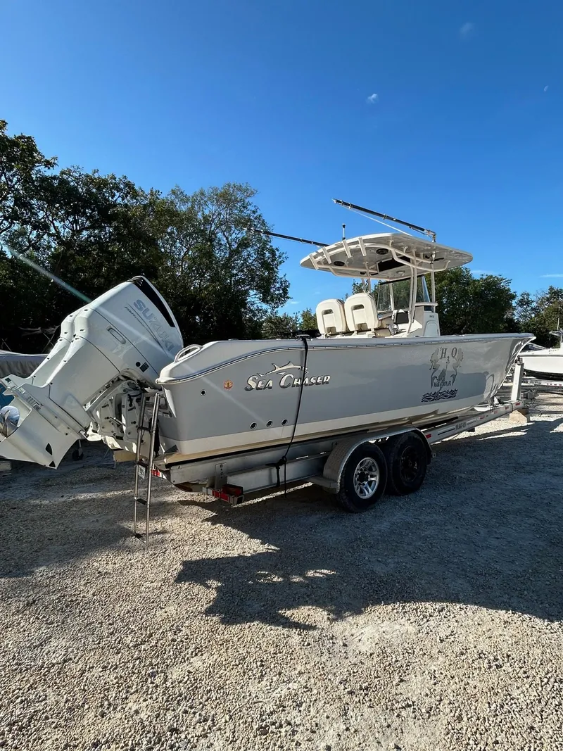 Slide: The Image of 2021 Sea Chaser 30 HFC DC boat on trailer, parked outdoors under clear blue sky. - 0