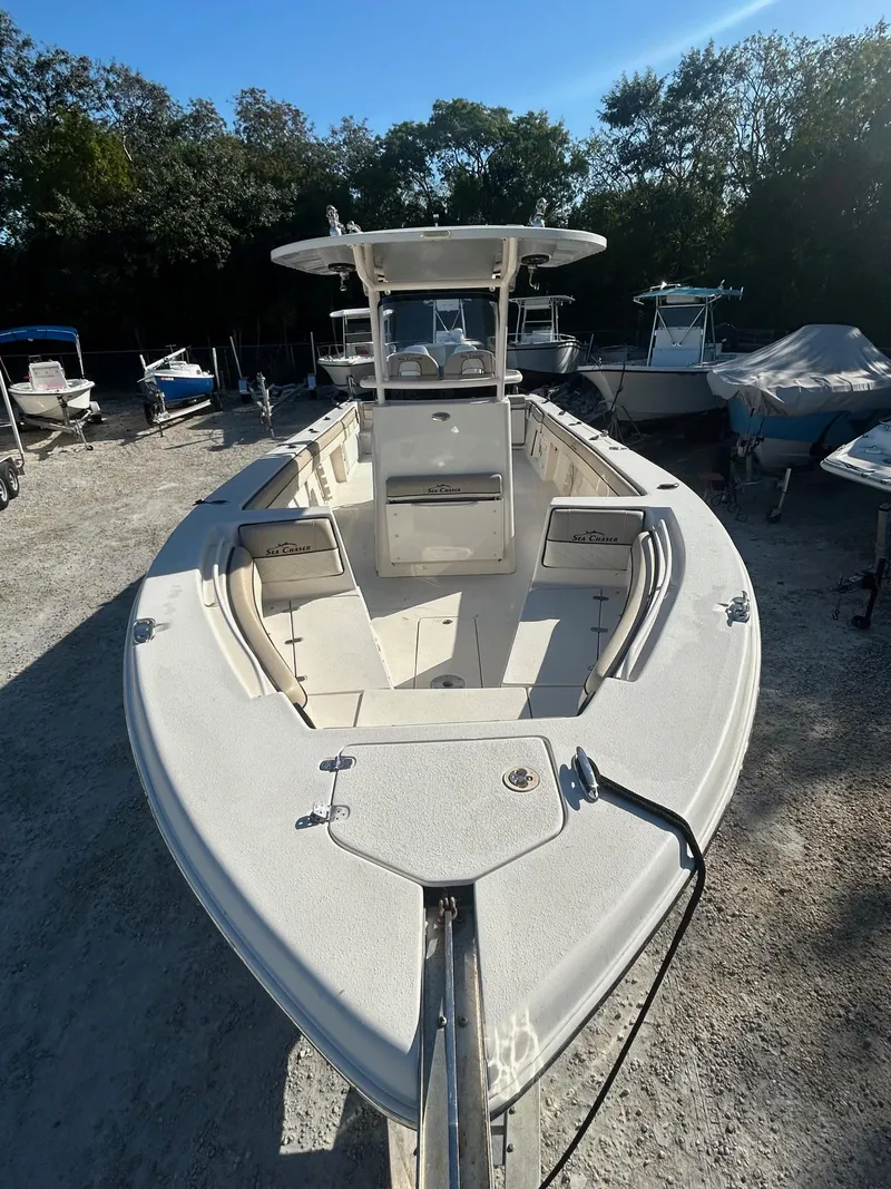 Slide: The Image of 2021 Sea Chaser 30 HFC DC boat, docked outdoors, surrounded by trees and other boats. - 1