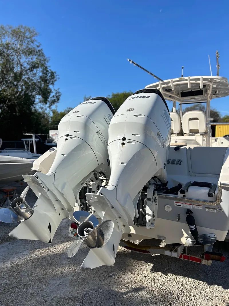 Slide: The Image of 2021 Sea Chaser 30 HFC DC boat with dual outboard engines, parked on gravel. - 2