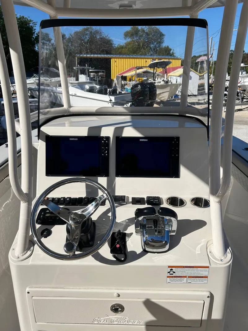 Slide: The Image of 2021 Sea Chaser 30 HFC DC boat dashboard with dual screens and steering wheel. - 5