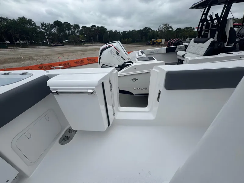 Slide: The Image of 2025 NauticStar 292 Legacy boat interior with seating and storage, under cloudy skies. - 10