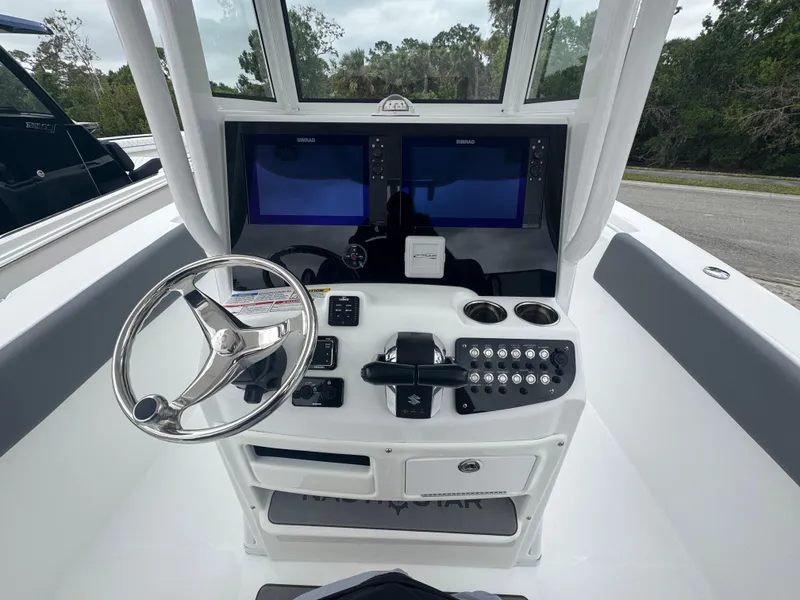Slide: The Image of 2025 NauticStar 292 Legacy boat helm with dual displays and steering wheel. - 16