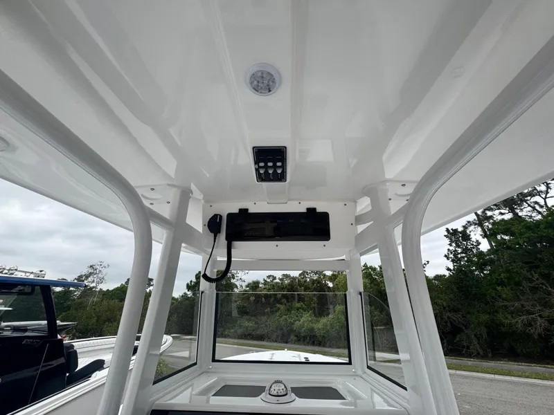 Slide: The Image of 2025 NauticStar 292 Legacy boat interior with control panel and overhead lighting. - 17