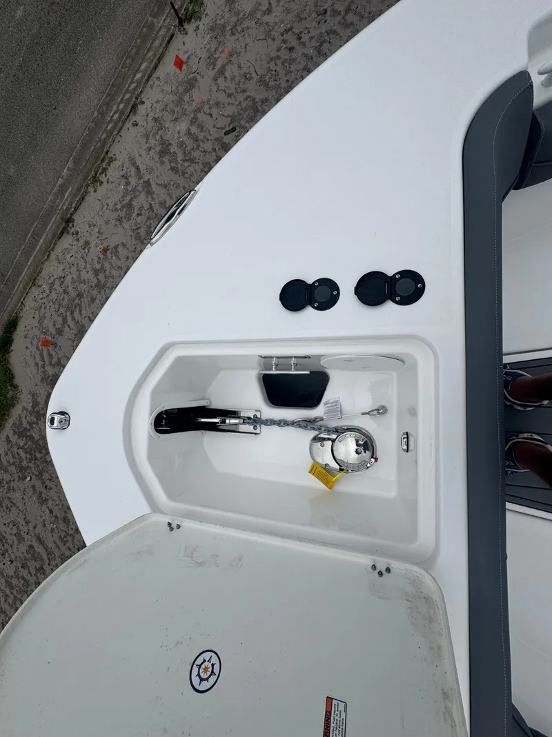 Slide: The Image of 2025 NauticStar 292 Legacy boat deck with anchor compartment and controls. - 19