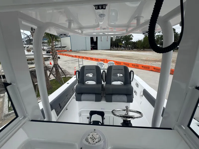 Slide: The Image of 2025 NauticStar 292 Legacy boat interior with dual seats and steering wheel. - 21