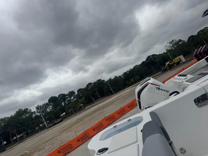 Slide: The Image of 2025 NauticStar 292 Legacy boat with Yamaha engines, cloudy sky, construction site background. - 23