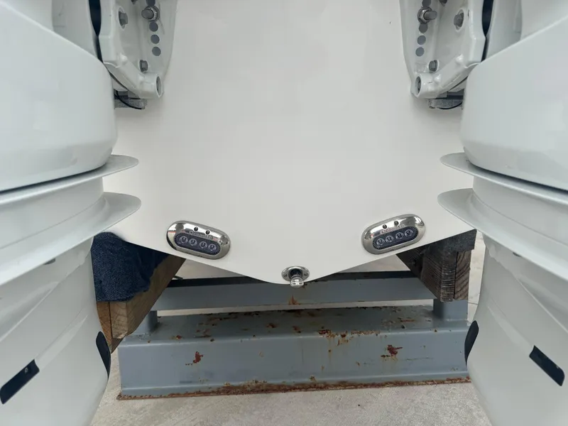 Slide: The Image of 2025 NauticStar 292 Legacy boat stern with dual outboard motors and underwater lights. - 25