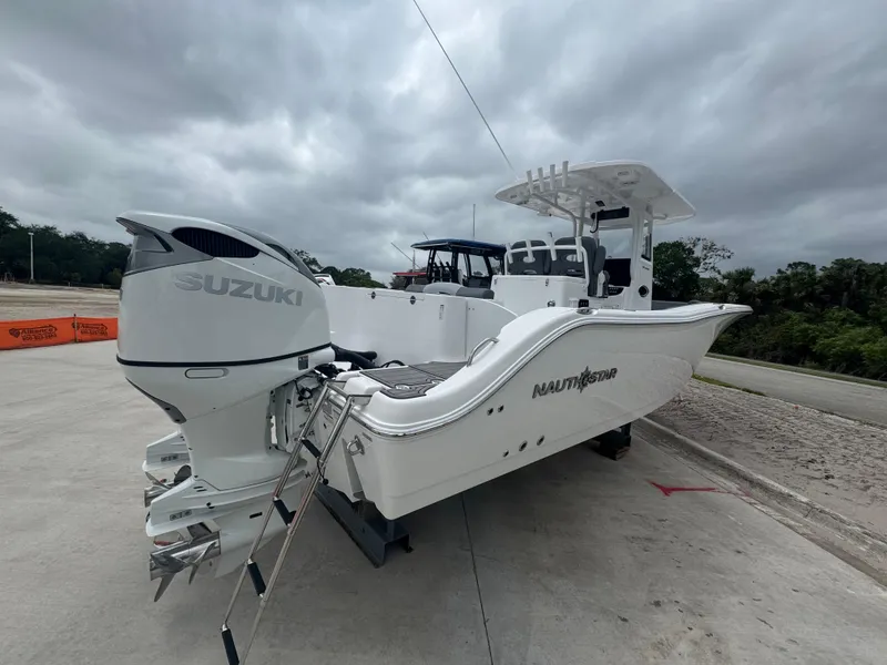 Slide: The Image of 2025 NauticStar 292 Legacy boat with Suzuki outboard motor on a cloudy day. - 6