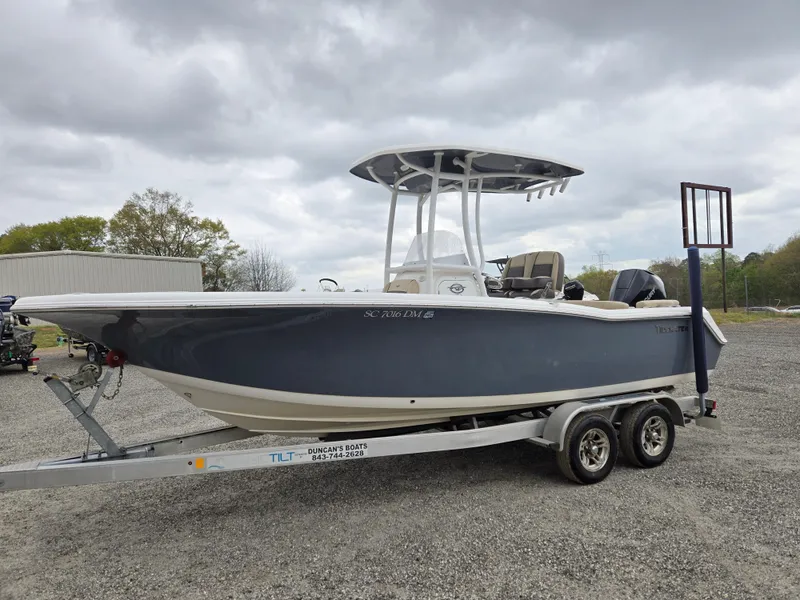 Slide: The Image of 2020 Tidewater 220 LXF boat on trailer, parked outdoors under cloudy sky. - 0