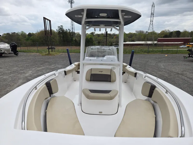 Slide: The Image of 2020 Tidewater 220 LXF boat with spacious seating and T-top, parked outdoors. - 10