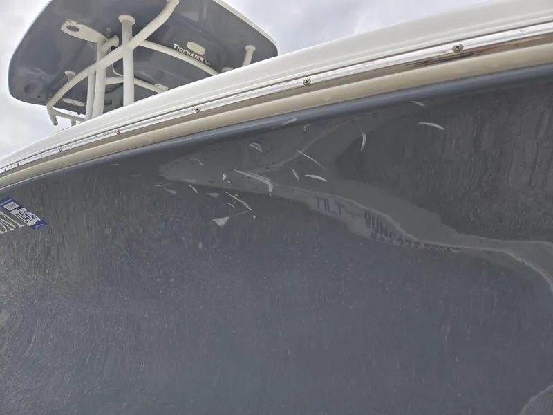 Slide: The Image of 2020 Tidewater 220 LXF boat hull with reflection and T-top visible. - 16