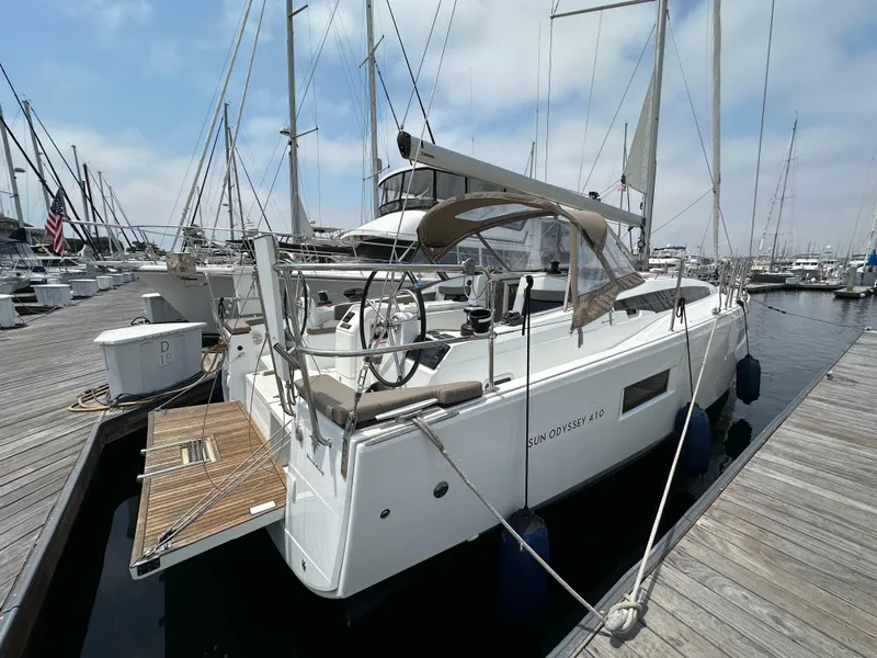 Slide: The Image of 2020 Jeanneau Sun Odyssey 410 sailboat docked at marina, featuring sleek design and spacious deck. - 12